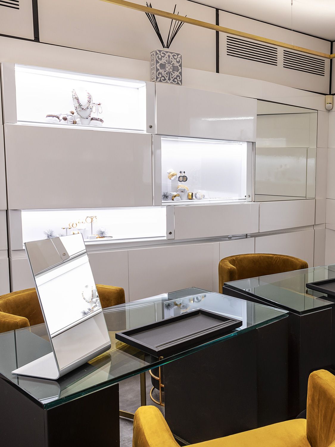 L’interno della boutique Fumis: il banco con lo specchio, le poltroncine e le vetrine illuminate